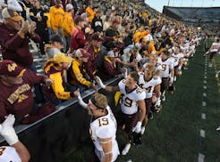 Minnesota celebrates with fans after their 12-10 win over Iowa in a NCAA college football game, Saturday, Oct. 21, 2023, in Iowa City, Iowa. (AP Photo