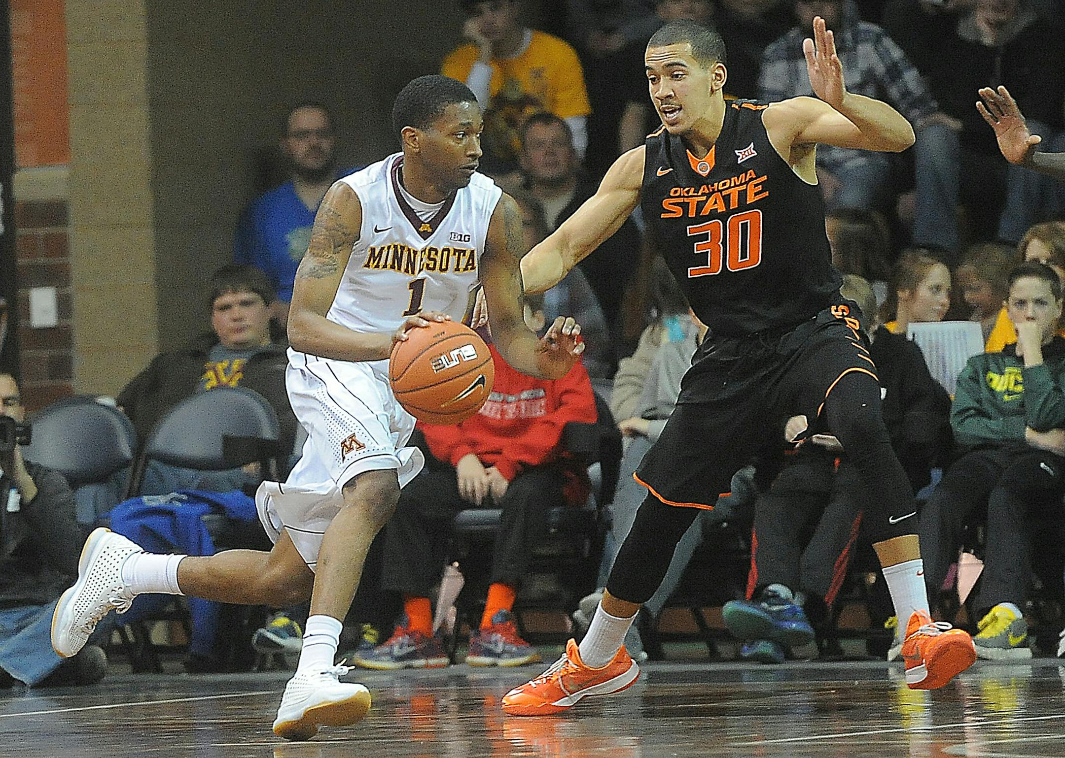 Minnesota's Dupree McBrayer dribbles the ball past Oklahoma State's Jeffrey Carroll during their game at the Sanford Pentagon in Sioux Falls on Saturday, Dec. 12, 2015. (Jay Pickthorn/The Argus Leader via AP) (AP Photo / Argus Leader, Jay Pickthorn)