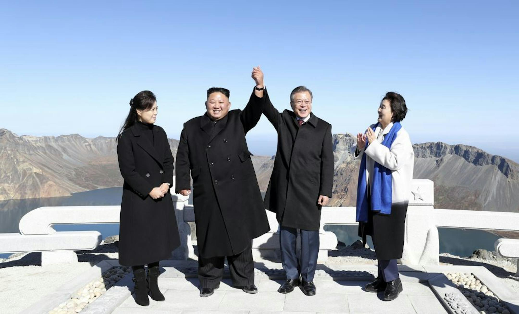 Kim Jong-un, second from left, the leader of North Korea, clasps hands with President Moon Jae-in of South Korea at the top of Baekdusan in Ryanggang, North Korea, Sept. 20, 2018. Moon urged the United States on Thursday to declare an end to the Korean War as an incentive for North Korea to denuclearize. (Pyongyang Press Corps/Pool via The New York Times) --FOR EDITORIAL USE ONLY --