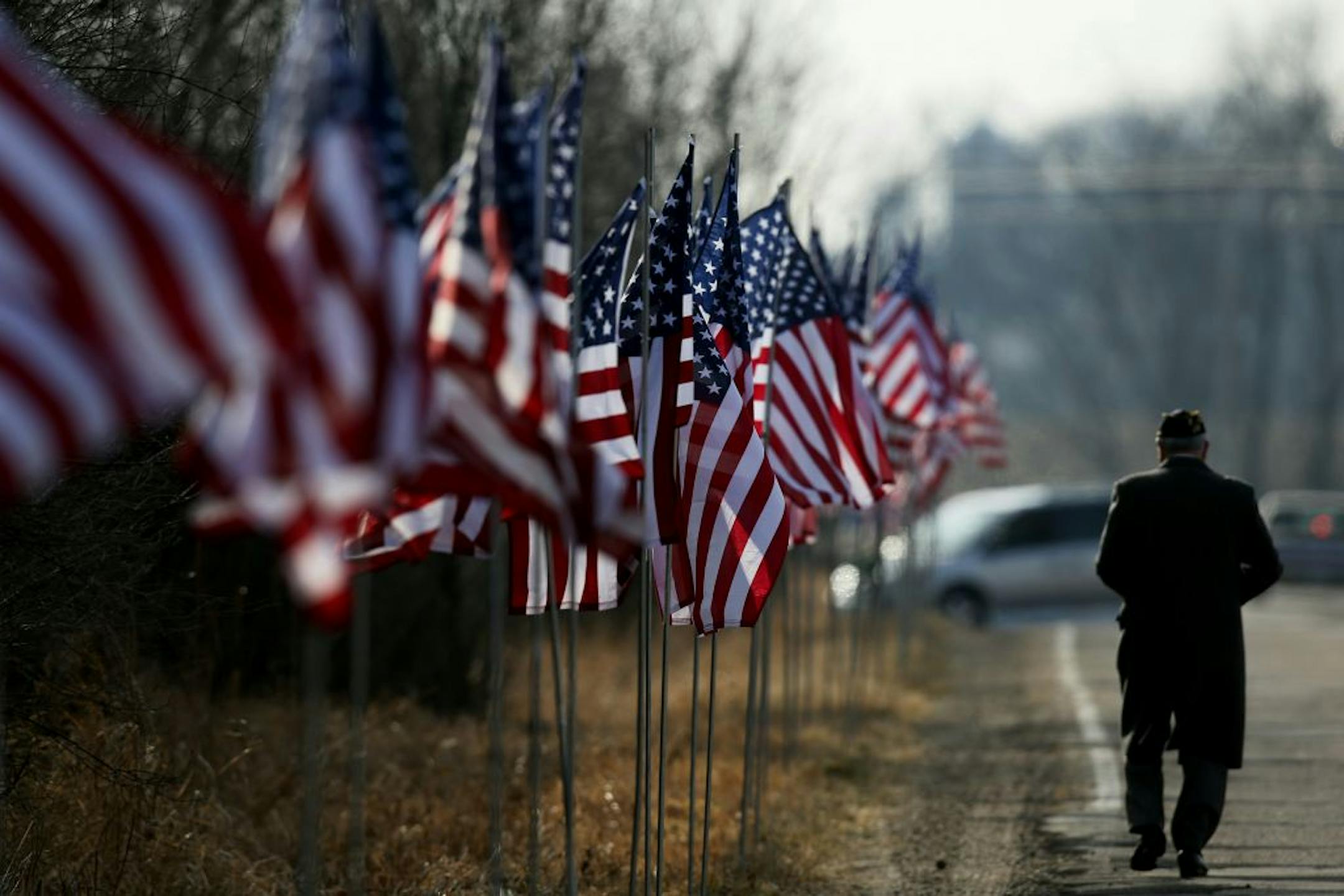 A man walked the flag-lined road after funeral services for Marine Lance Corporal Dale Means.