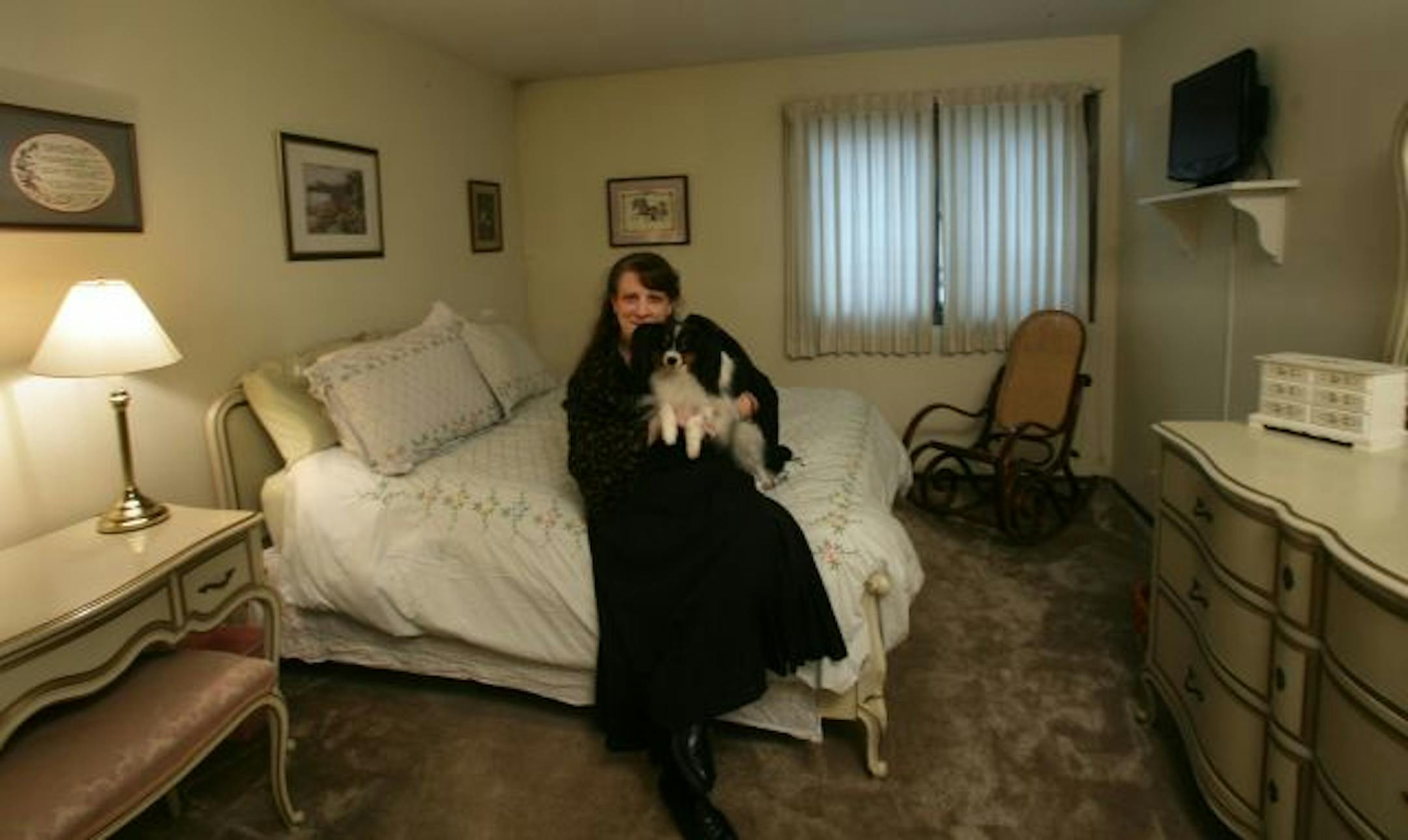 Jeanne Leier with her dog Louis in her organized bedroom.