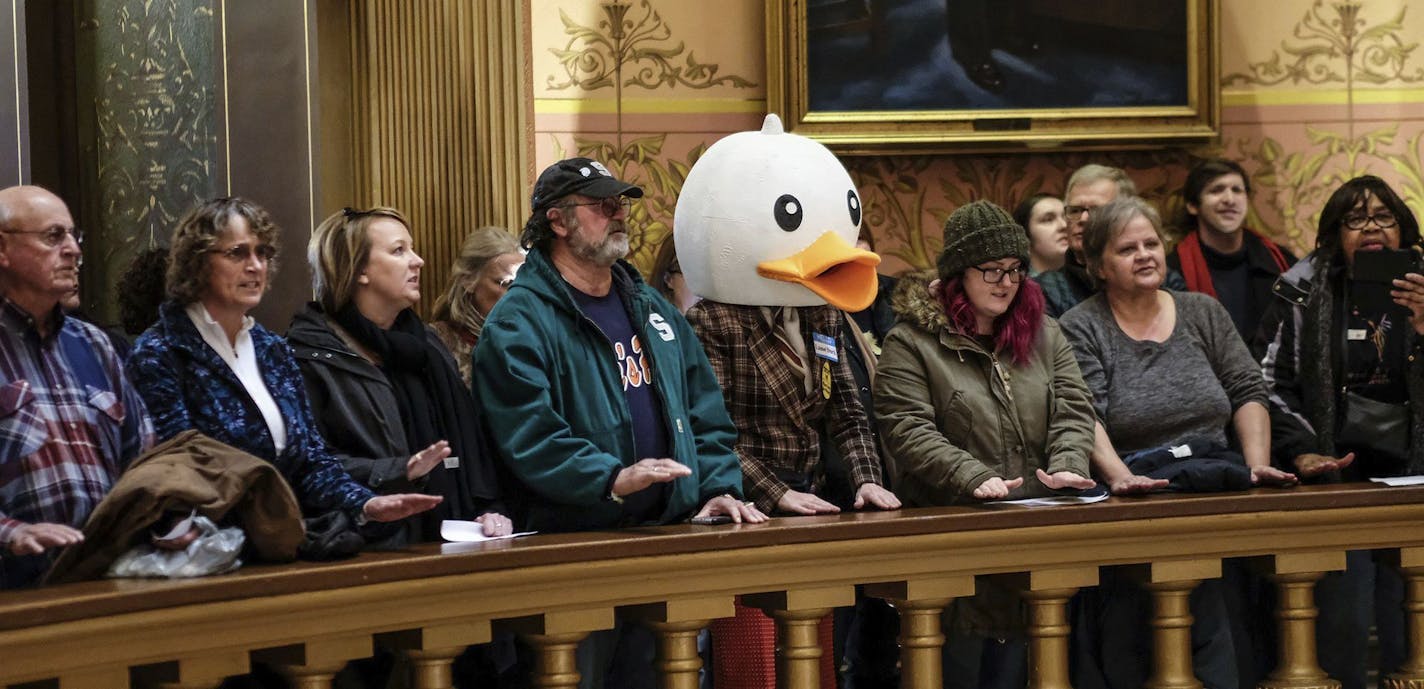 In this Tuesday, Dec. 4, 2018, photo, people gather to protest at the Capitol Rotunda in Lansing, Mich. The incoming Democratic governor of Wisconsin said Wednesday that he plans to make a personal appeal to his defeated rival, Gov. Scott Walker, to veto far-reaching GOP legislation that would restrict the new administration's powers. (Robert Killips/Lansing State Journal via AP)