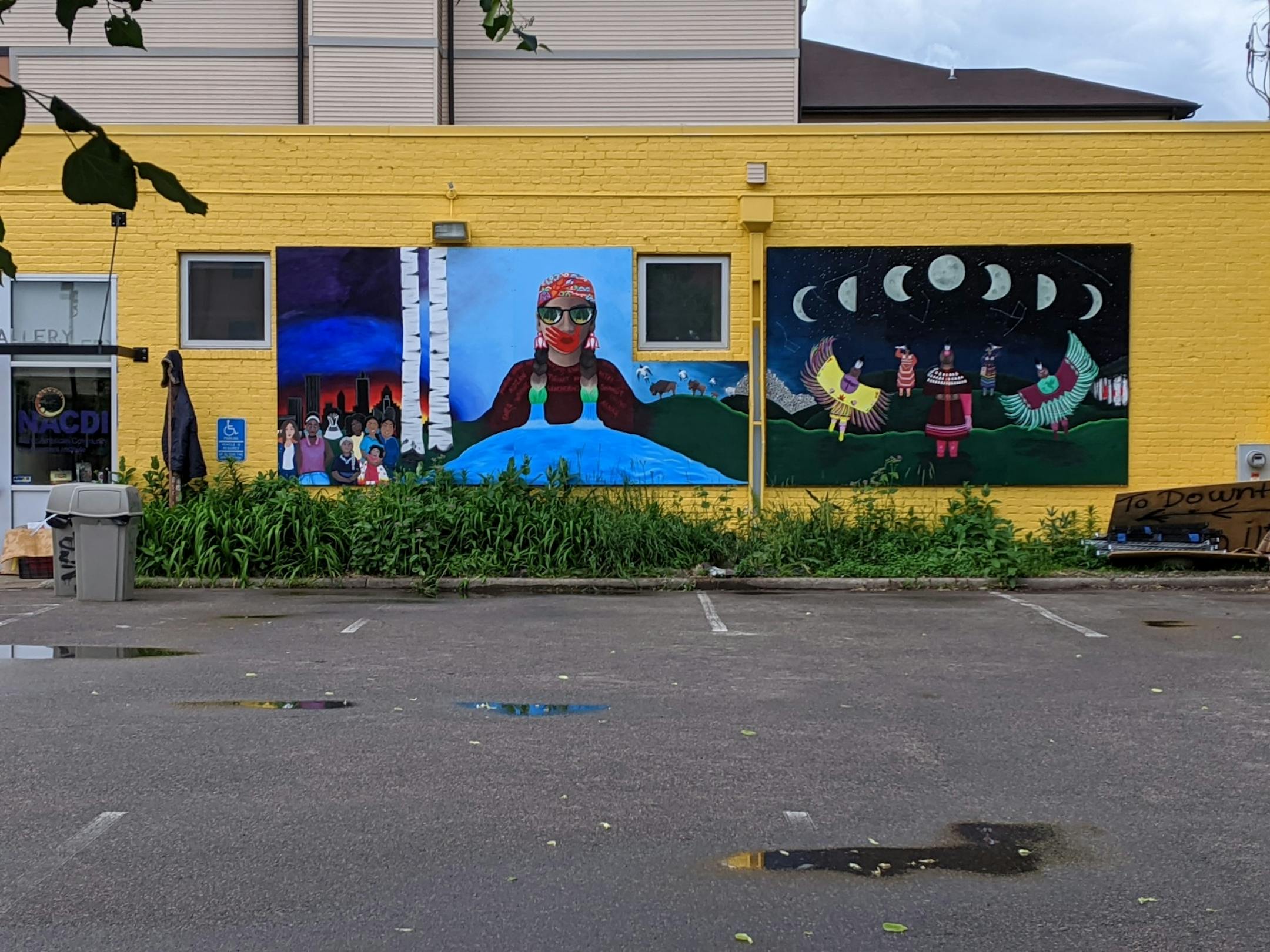 Murals painted onto the side of All My Relations Art Gallery during a community event in June.