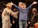 Conductor Andrew Davis, right, raises his arms as he takes a bow, accompanied by Renee Fleming, and Peter Rose, center, during the final dress rehears