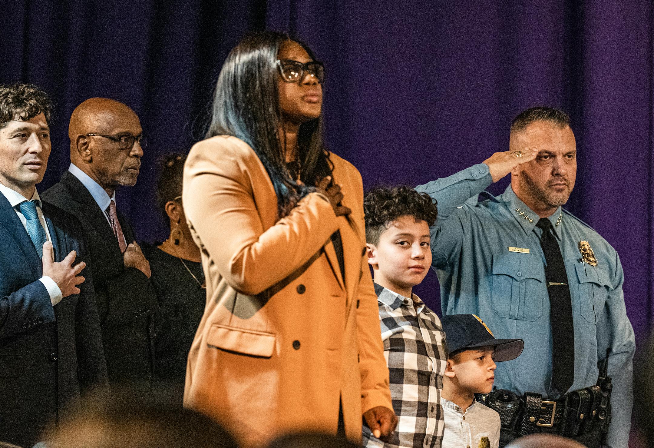 Brian O'Hara salutes during a ceremony for him to besworn in as the new Minneapolis Chief of Police. His wife, Wafiyyah, and sons Brendan,11, and Seamus,6, stand by him at Shiloh Temple.