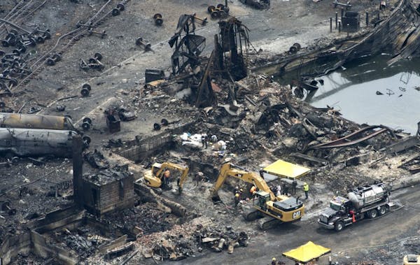 This aerial photo, workers comb through the debris after a train derailed causing explosions of railway cars carrying crude oil Tuesday, July 9, 2013 