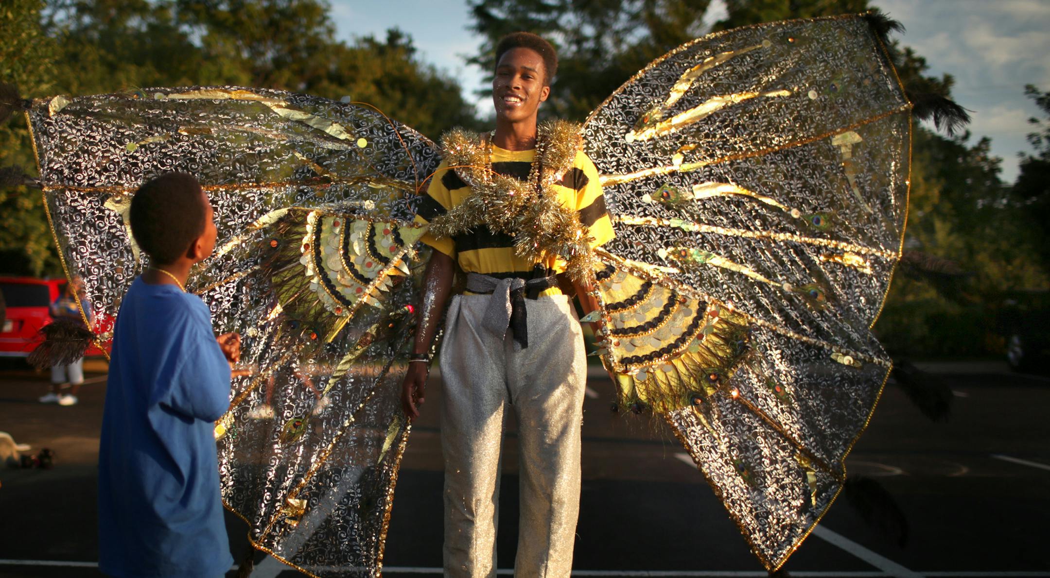 Jamar Edwards answered questions about his bee costume from a pair of curious young admirers while waiting for the parade to begin. He was going to march with the group from Twin Cities Cari Fest, which is holding a Carribean themed festival this weekend. ] JEFF WHEELER Ô jeff.wheeler@startribune.com The Minneapolis Aquatennial's 2015 CenterPoint Energy Torchlight Parade was held Wednesday night, July 22, 2015 on Hennepin Ave. in downtown Minneapolis. ORG XMIT: MIN1507222109191708