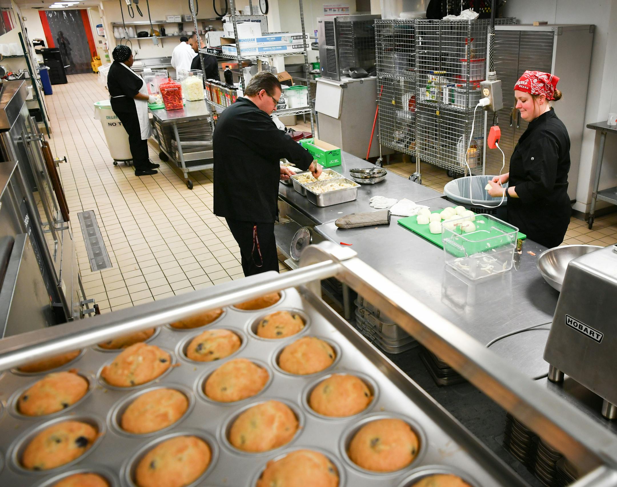 Executive Chef Kris Almsted, center, prepared a batch of vegetarian Alfredo for the grand opening of the new Meals on Wheels kitchen. A batch of fresh baked blueberry muffins in the foreground for the grand opening. ] GLEN STUBBE • glen.stubbe@startribune.com Wednesday May 3, 2017 Meals on Wheels is opening its first kitchen specifically dedicated to serving Meals on Wheels recipients in the Twin Cities. The organization says it's a big deal, especially amid current uncertainties around f