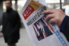 FILE - In this Nov. 10, 2016 file photo, a man reads a newspaper with the headline that reads "U.S. President-elect Donald Trump delivers a mighty sho