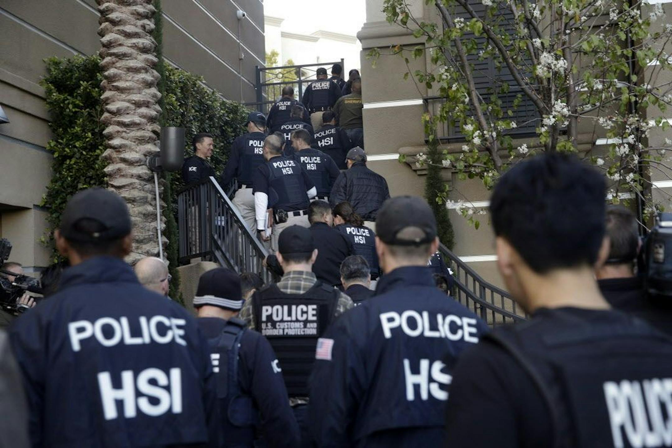Federal agents enter an upscale apartment complex, Tuesday, March 3, 2015, in Irvine, Calif.