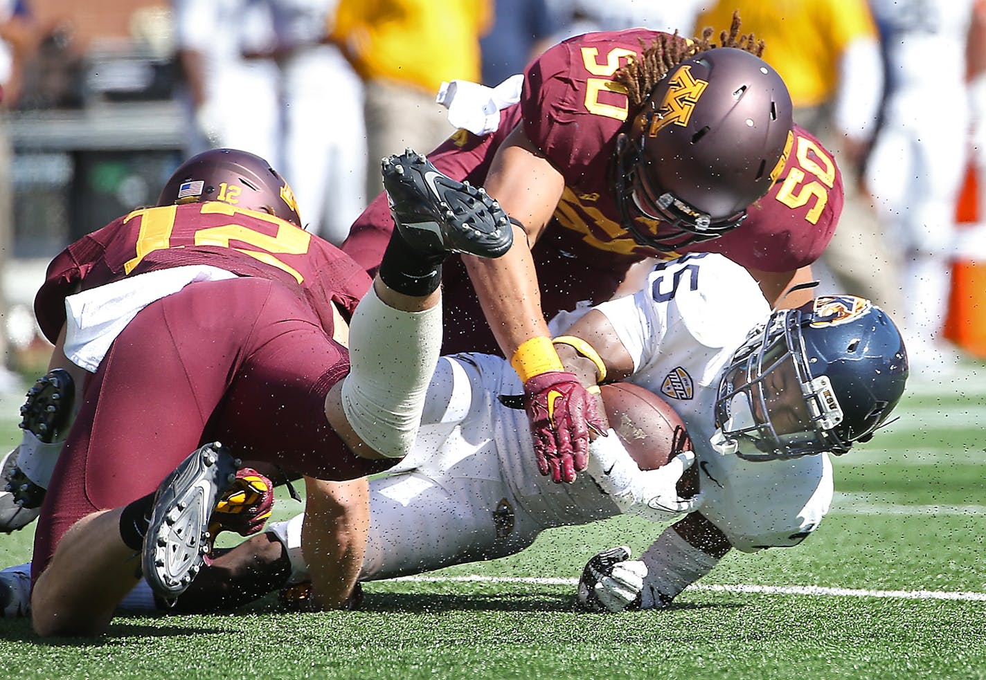 Minnesota's linebacker Cody Poock, left, and Minnesota's linebacker Jack Lynn stopped Kent State wide receiver Ernest Calhoun quarter as the Gophers took on Kent State at TCF Bank Stadium, Saturday, September 19, 2015 in Minneapolis, MN.