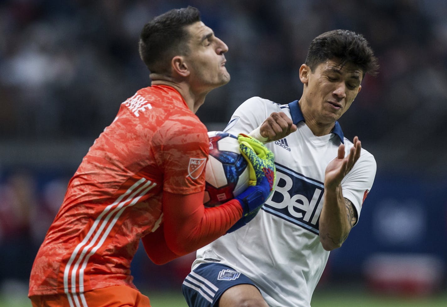 Minnesota United goalkeeper Vito Mannone (1) makes a save near Vancouver Whitecaps' Fredy Montero (12) during the second half of an MLS soccer match Saturday, March 2, 2019, in Vancouver, British Columbia. (Ben Nelms/The Canadian Press via AP)