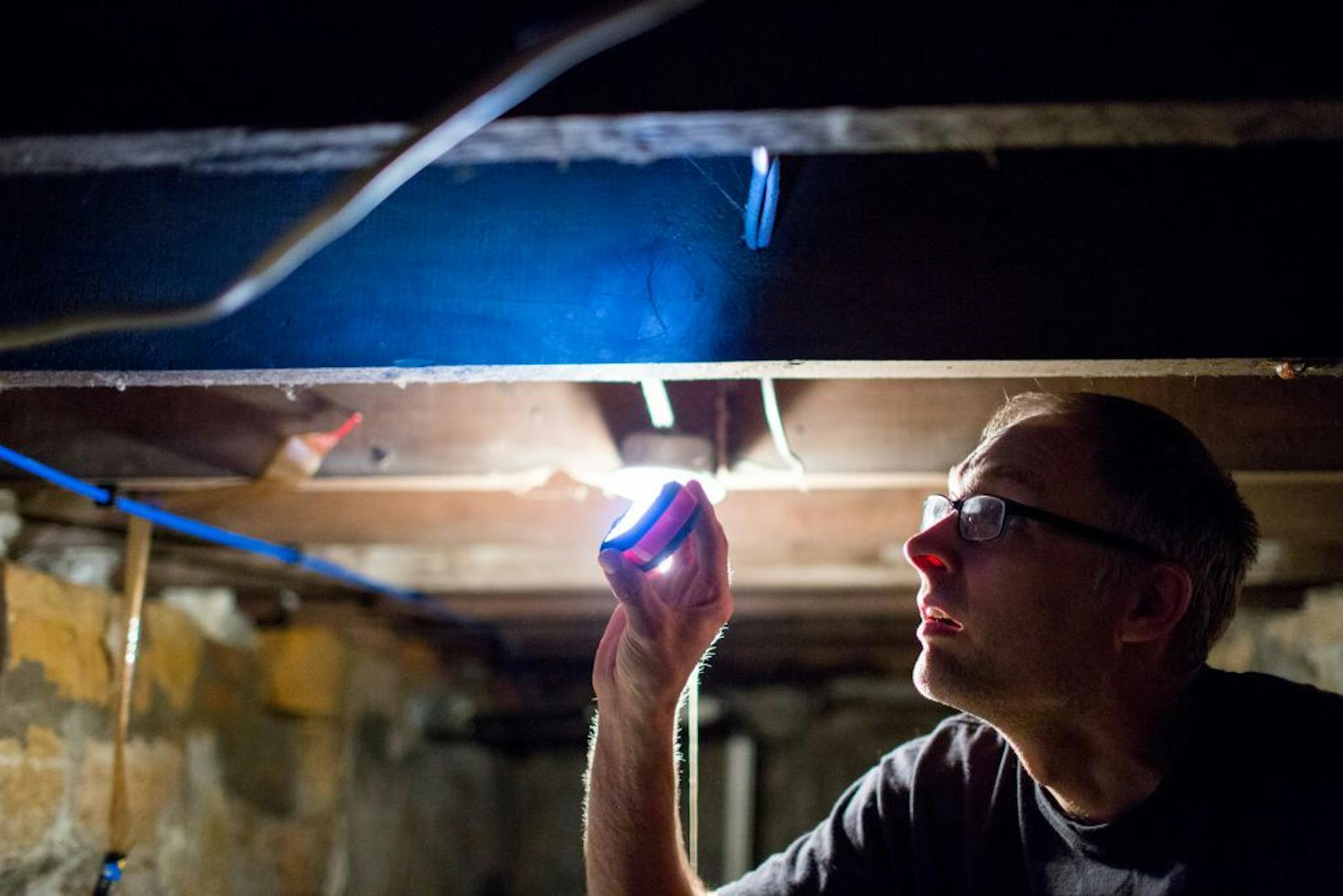 Brent Helgeson looks at the splintered wood in the ceiling of his basement.
