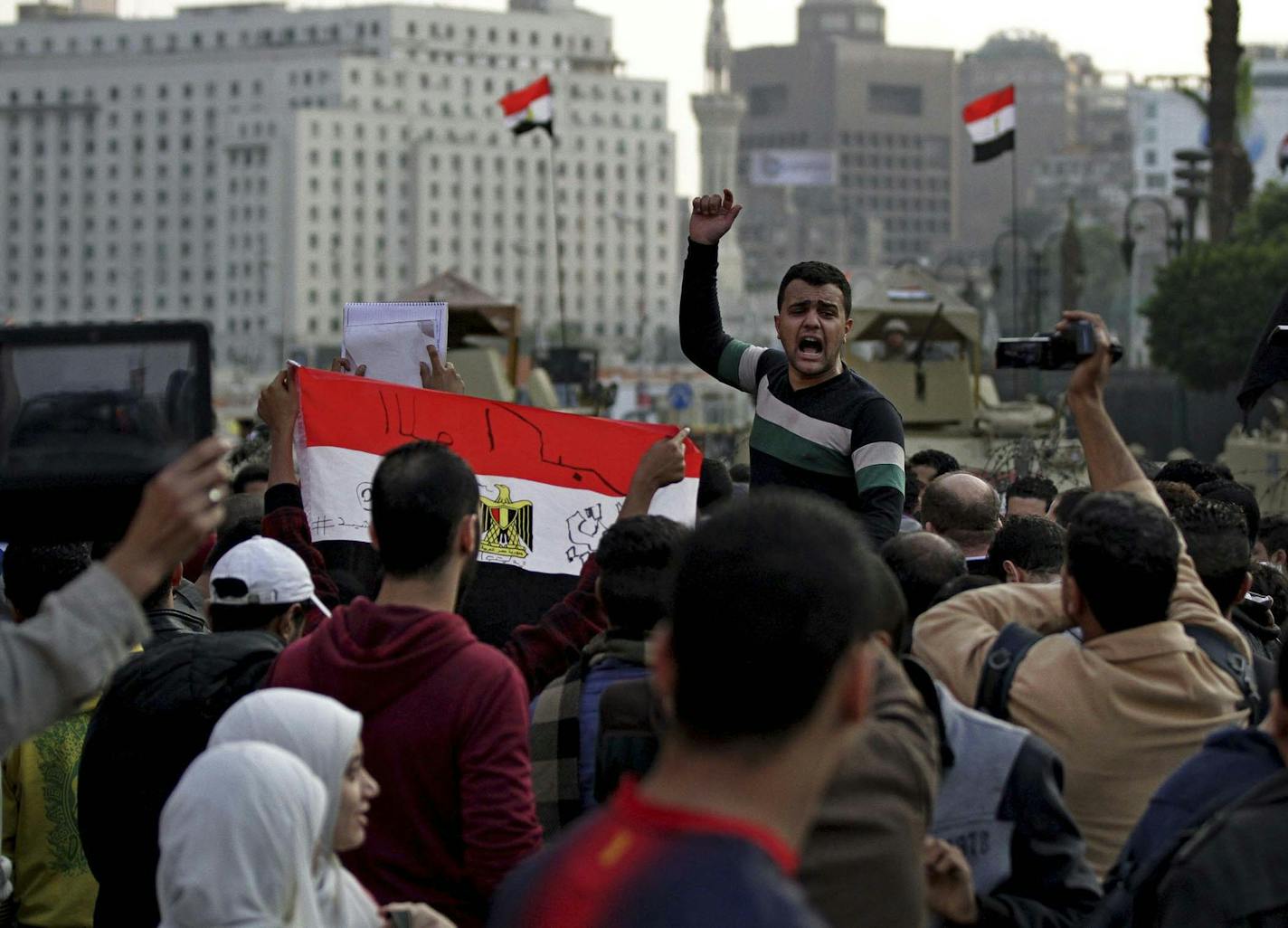 Protesters shout anti-government slogans and hold a national flag with "God is great written on it," after a judge on Saturday dismissed the case against former President Hosni Mubarak and acquitted his security chief over the killing of hundreds of protesters during Egypt&#x2019;s 2011 uprising, near Tahrir Square, Cairo, Egypt, Saturday, Nov. 29, 2014. The court ruling received a muted initial reaction in an Egypt where unlicensed protests draw stiff prison terms. Later Saturday several thousa