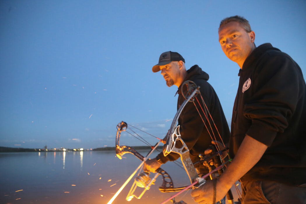Kirschbaum and Sassen watch the shallow water of a Mississippi River Bay closely, looking for carp and other 
