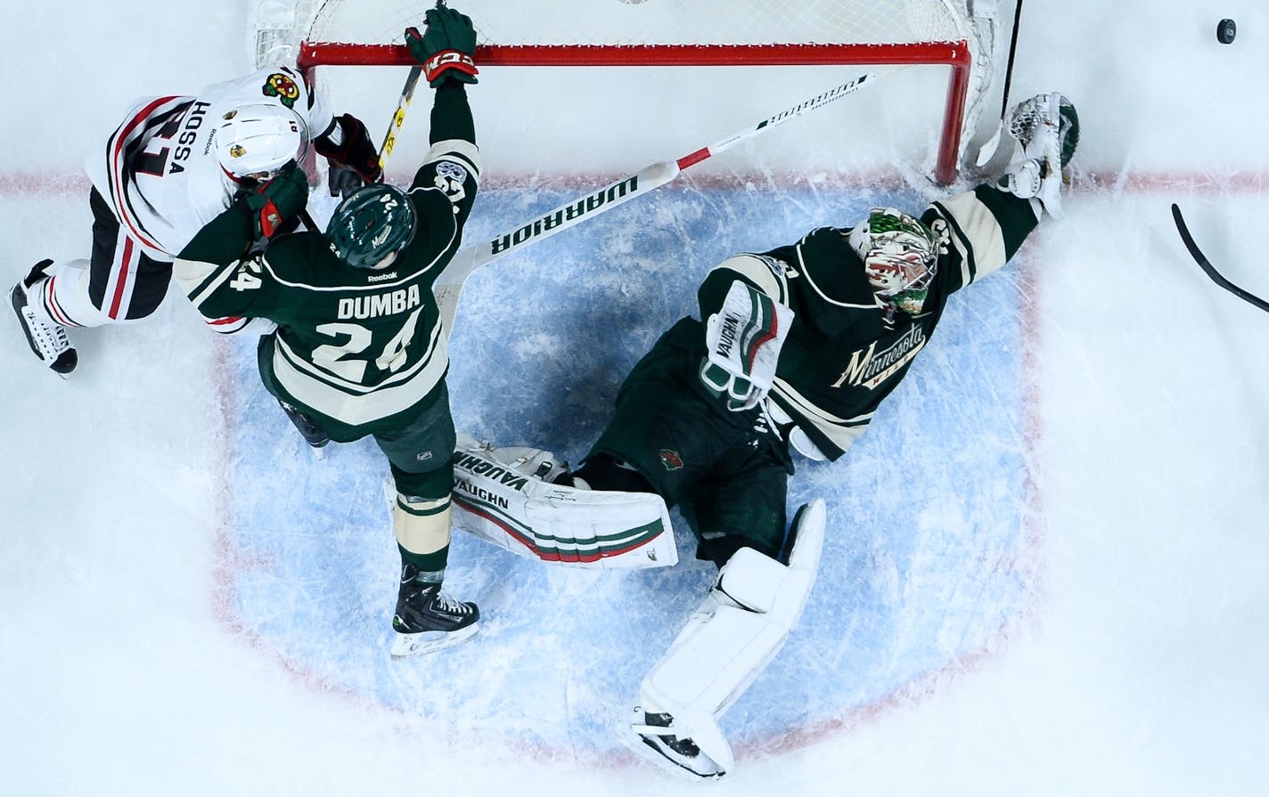 Minnesota Wild goalie Darcy Kuemper (35) blocked a shot by Chicago Blackhawks defenseman Brian Campbell (51) as Minnesota Wild defenseman Matt Dumba (24) and Chicago Blackhawks right wing Marian Hossa (81) battled outside the crease in the final seconds of the first period.