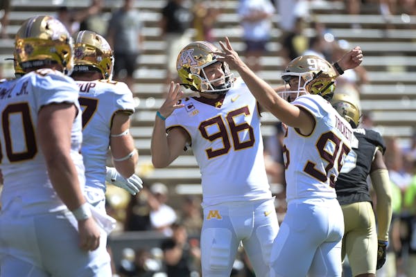 Minnesota Gophers holder Mark Crawford (96) and place kicker Matthew Trickett (95) celebrated a successful point after attempt by Trickett in the four
