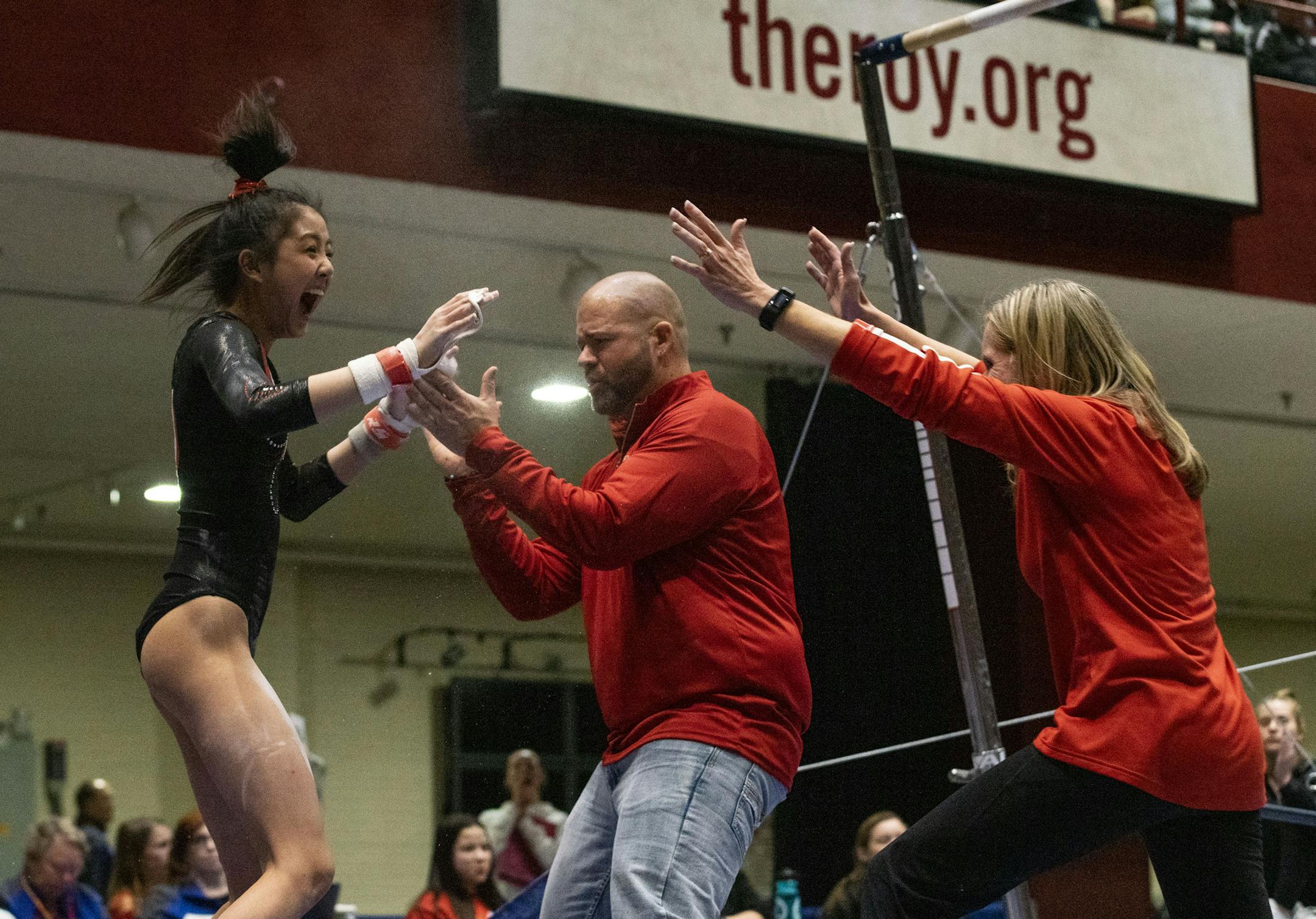 Lakeville North's Kaitlyn Nguyen celebrated her performance on the uneven parallel bars with her gymnastics coaches Friday at Roy Wilkins Auditorium.