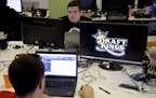 In this Wednesday, Sept. 9, 2015, photo, Len Don Diego, marketing manager for content at DraftKings, a daily fantasy sports company, works at his stat