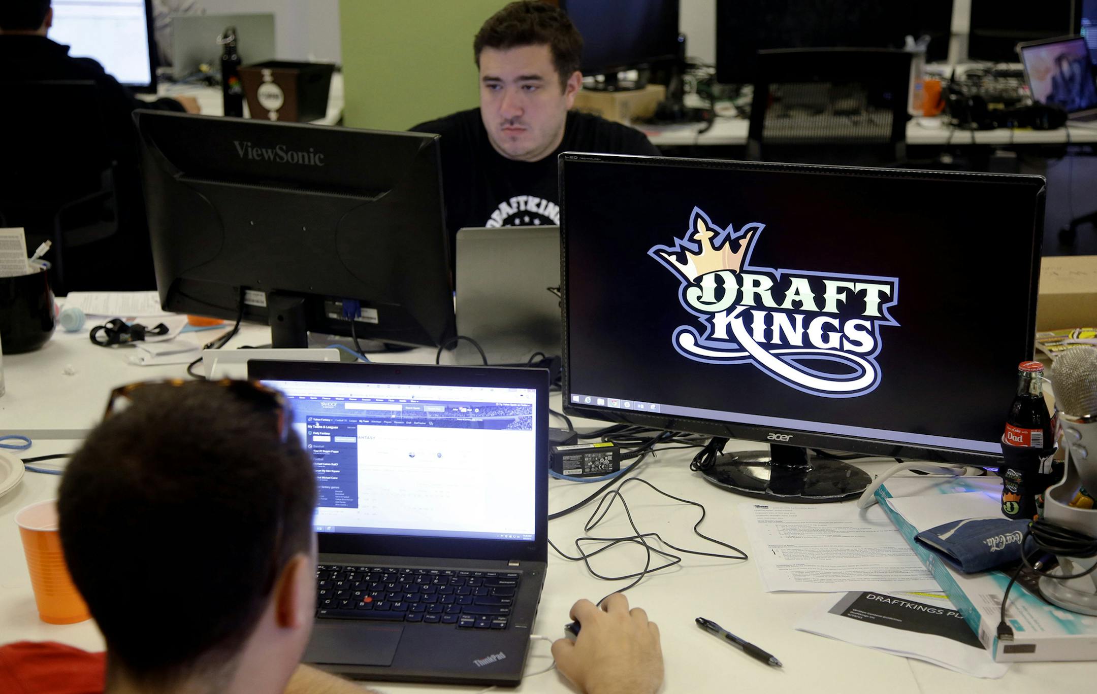 In this Wednesday, Sept. 9, 2015, photo, Len Don Diego, marketing manager for content at DraftKings, a daily fantasy sports company, works at his station at the company's offices in Boston. The daily fantasy sports industry is eyeing a breakout season as NFL games begin. And its two dominant companies, DraftKings and FanDuel, are touting lucrative opening week prizes to try to draw more customers as more competitors pop up. (AP Photo/Stephan Savoia) ORG XMIT: MIN2015092217104777 ORG XMIT: MIN151