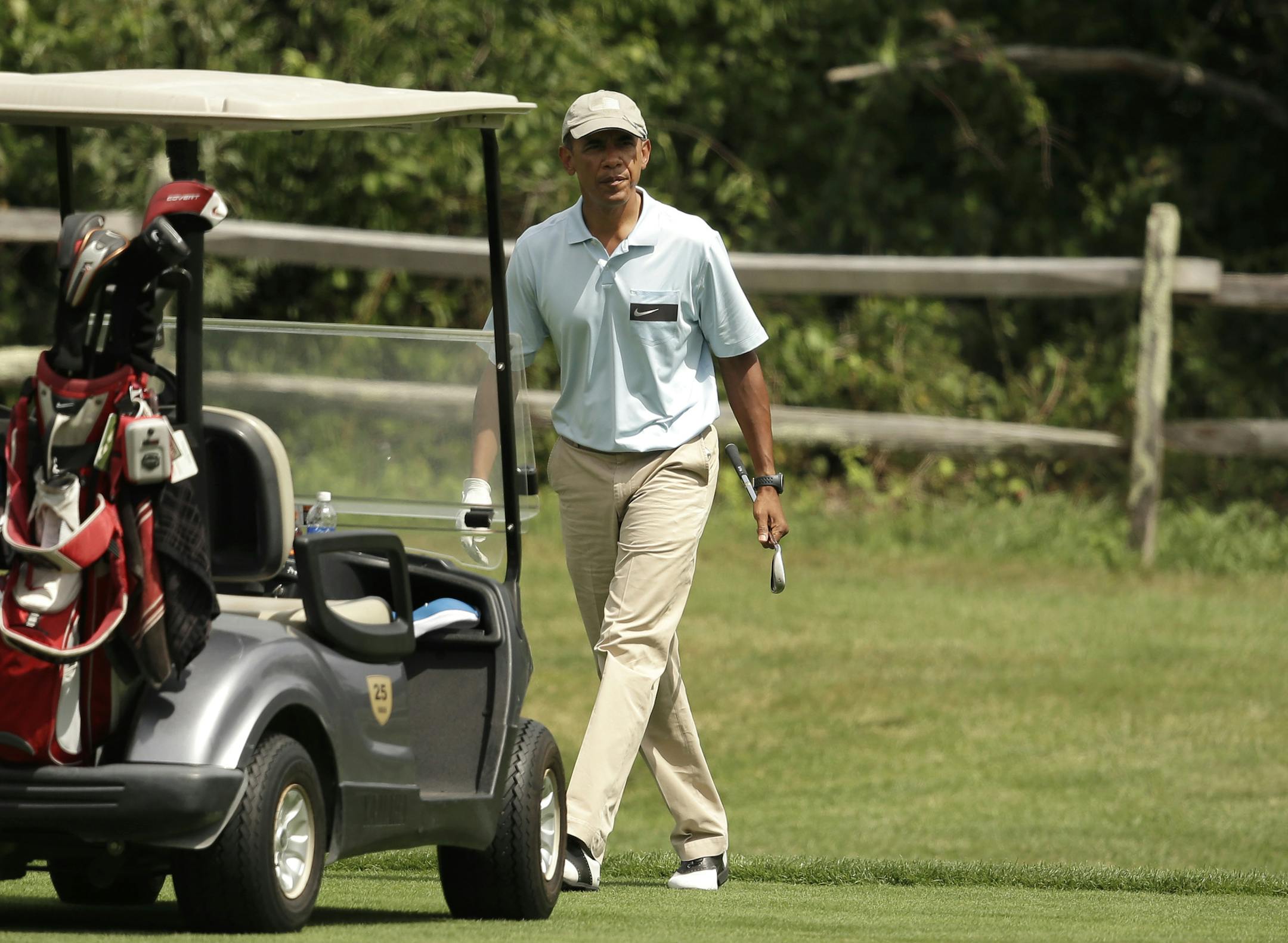 President Barack Obama walks back to the golf cart while golfing at Farm Neck Golf Club, in Oak Bluffs, Mass., on the island of Martha's Vineyard, Sunday, Aug. 19, 2014. In a rare move for him, the president planned a break in the middle of his Martha's Vineyard vacation to return to Washington Sunday night for unspecified meetings with Vice President Joe Biden and other advisers. (AP Photo/Steven Senne)