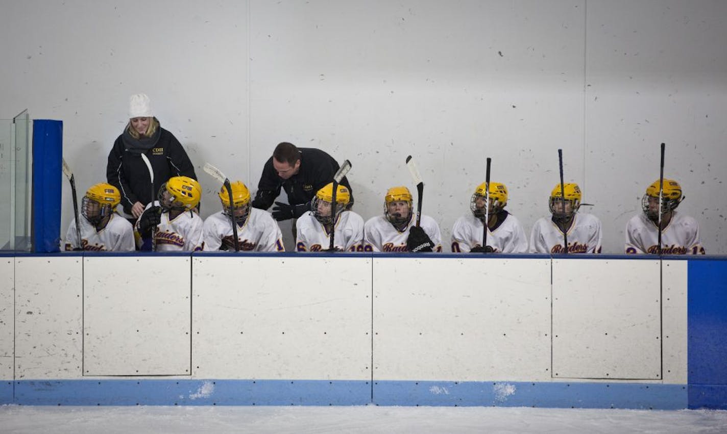 Krissy and Johnny Pohl talked to the players on the bench during a mid-December home game against Stillwater at Charles M. Schultz-Highland Arena.