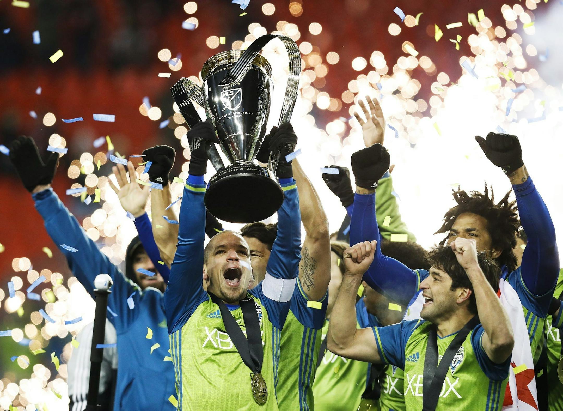 Seattle Sounders midfielder Osvaldo Alonso, front left, hoists soccer's MLS Cup with teammates after defeating Toronto FC on Dec. 10, 2016. Alonso is expected to sign with Minnesota United, a source said Monday.