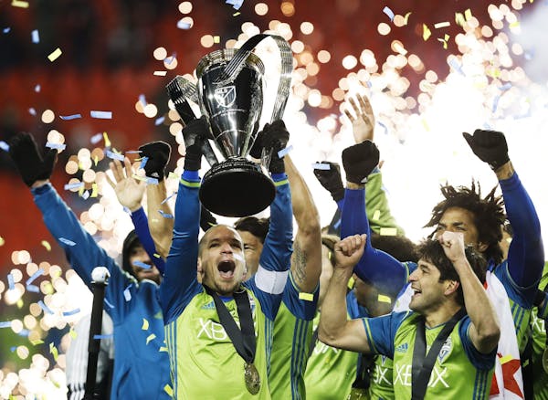Seattle Sounders midfielder Osvaldo Alonso, front left, hoists soccer's MLS Cup with teammates after defeating Toronto FC on Dec. 10, 2016. Alonso is 