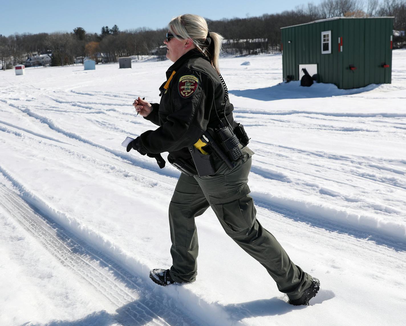 Minnesota Department of Natural Resources conservation officer Leah Weyandt walked to talk with anglers about the upcoming deadline to remove their ice fishing shelters Thursday at Lake Minnetonka. ] ANTHONY SOUFFLE &#xef; anthony.souffle@startribune.com Minnesota Department of Natural Resources conservation officers Brent Grewe and Leah Weyandt talked with anglers about the upcoming deadline to remove their ice fishing shelters Thursday, March 1, 2018 on Lake Minnetonka in Wayzata, Minn.