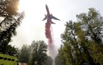 A tanker drops fire retardant on a fire that flared-up Thursday, Aug. 20, 2015, in Twisp, Wash. ildfires rampaged across the drought-choked West on Th