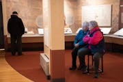 Visitors watch an oral history video in the "Many Voices, Many Stories, One Place" exhibit on Thursday at Historic Fort Snelling in St. Paul. The exhi