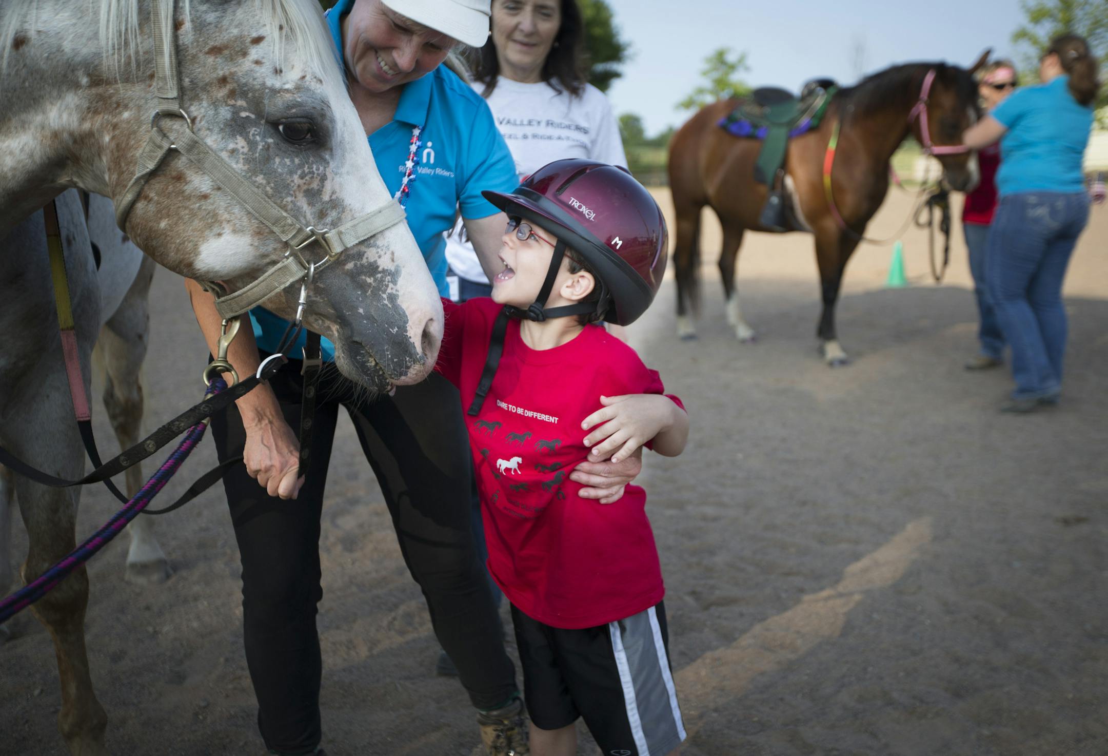 Keagen Dyson said goodbye to his horse Newman after riding him as part of therapeutic horseback riding lesson offered by a nonprofit called River Valley Riders on Wednesday, July 1, 2015, in Afton, Minn. Also pictured is path certified instructor Cheryl Holt in blue. ] RENEE JONES SCHNEIDER • reneejones@startribune.com