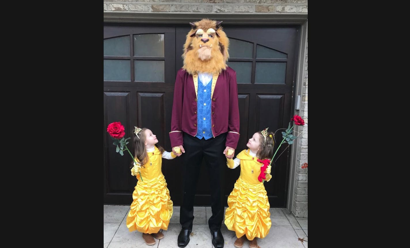 Joe Mauer and his twin daughters Emily and Maren as Beauties and the Beast for Halloween.