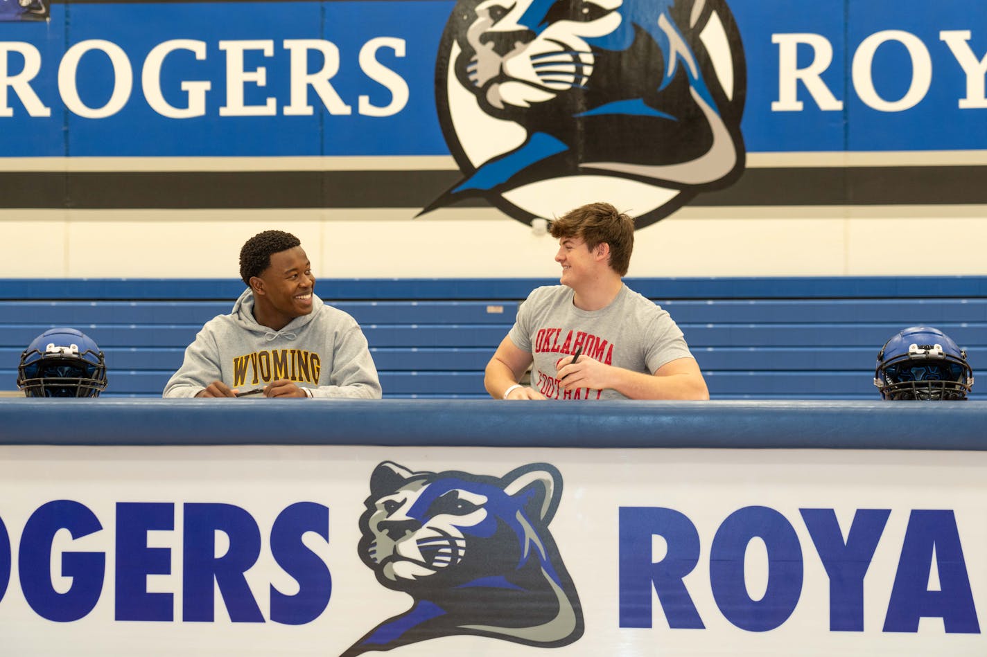 Adrian Onyiego and Wyatt Gilmoreon talk before they sign their letter of intent to play football at Wyoming and Oklahoma respectively on National Signing Day at Rogers High School on Wednesday, Dec. 20, 2023. Photo by Matt Blewett, Special to Star Tribune matt@mattebphoto.com