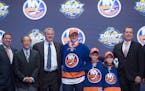 Kieffer Bellows, center, stands with members of the New York Islanders management team and others at the NHL draft in Buffalo, N.Y., Friday June 24, 2