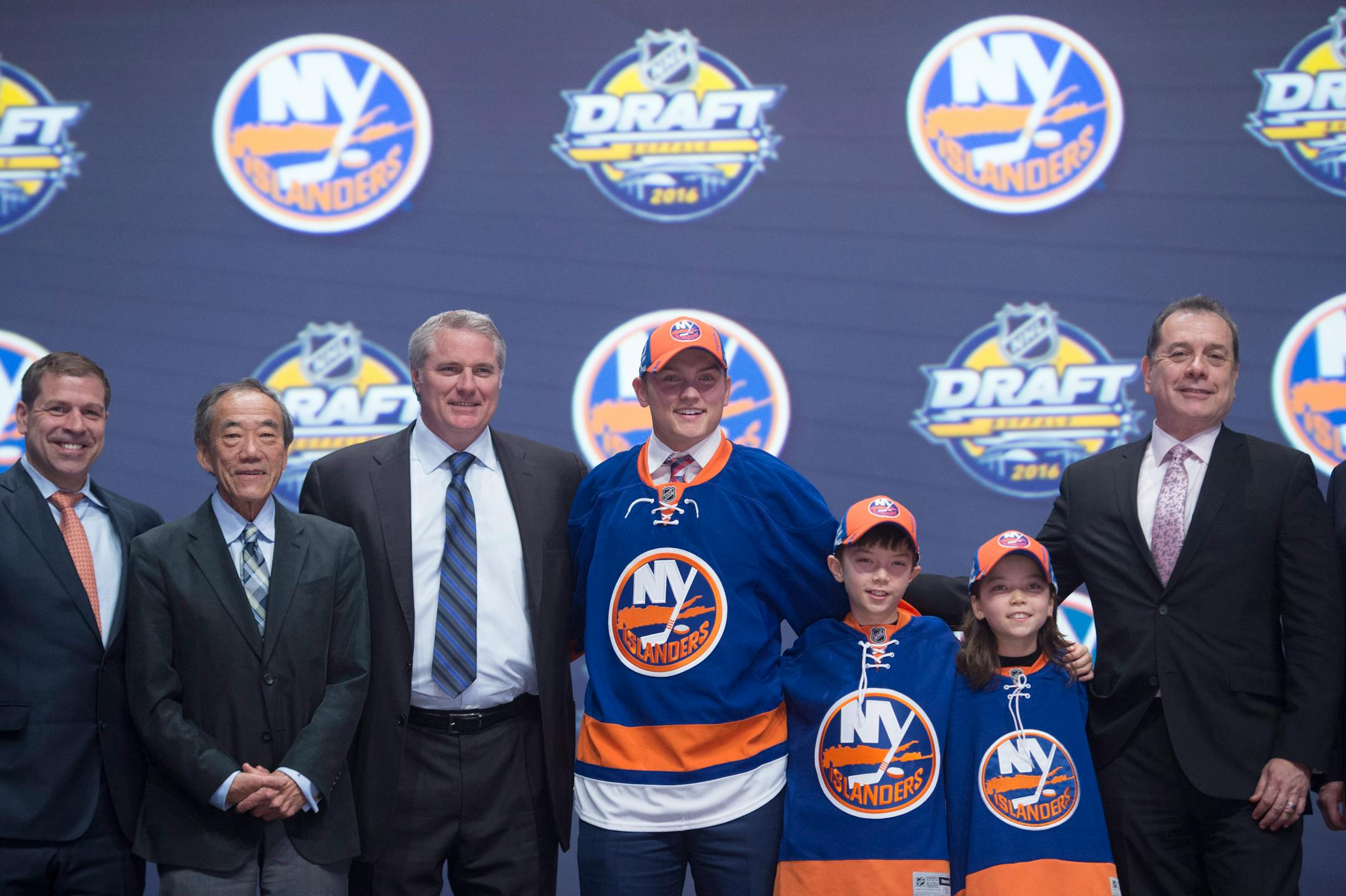 Kieffer Bellows, center, stands with members of the New York Islanders management team and others at the NHL draft in Buffalo, N.Y., Friday June 24, 2016.