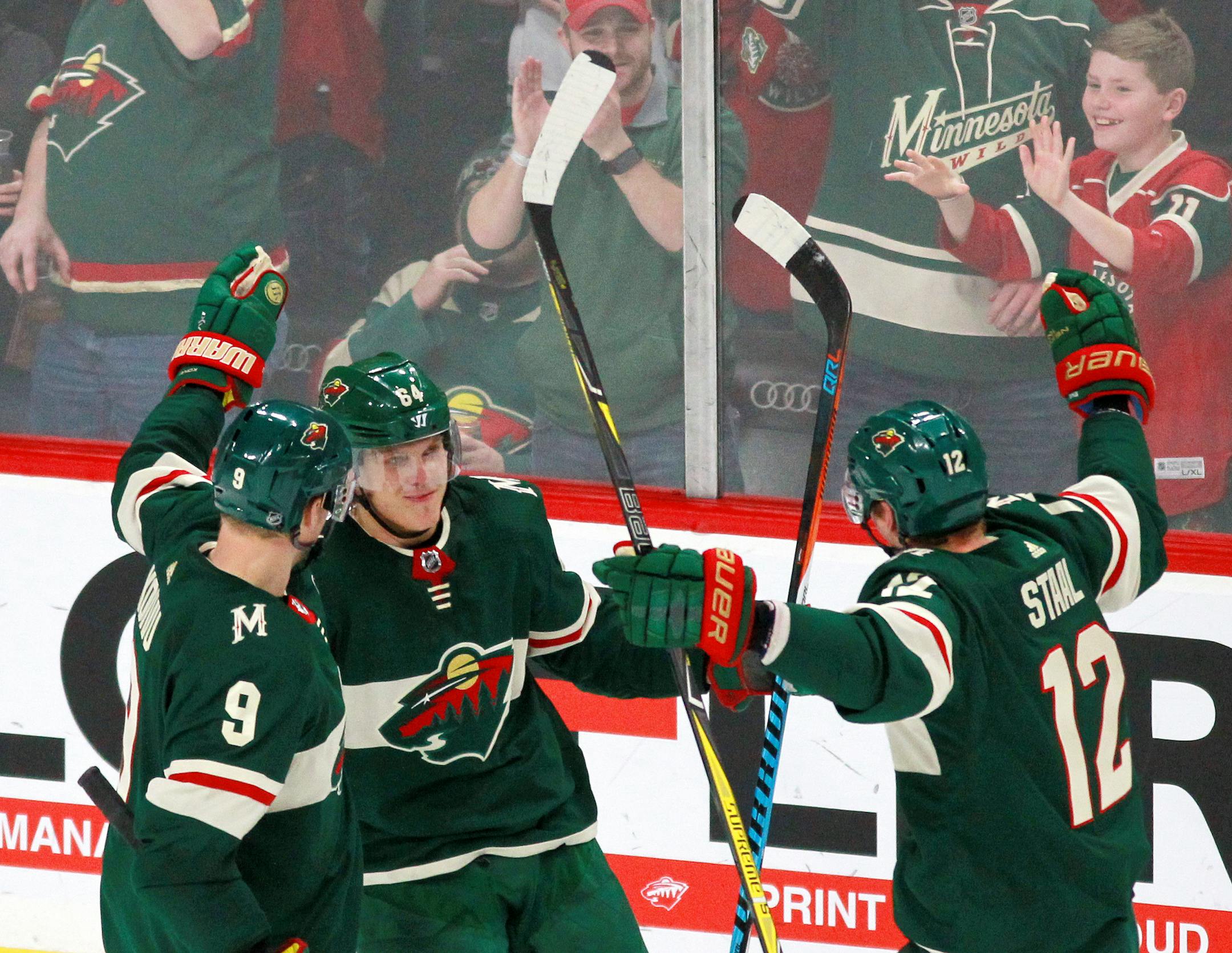 Minnesota Wild's Mikael Granlund (64) celebrated his third goal of the game with Wild teammates Mikko Koivu (9) and Eric Staal (12) against the Nashville Predators during the third period of an NHL hockey game on Friday, Dec. 29, 2017, in St. Paul, Minn. The Wild beat the Predators 4-2.