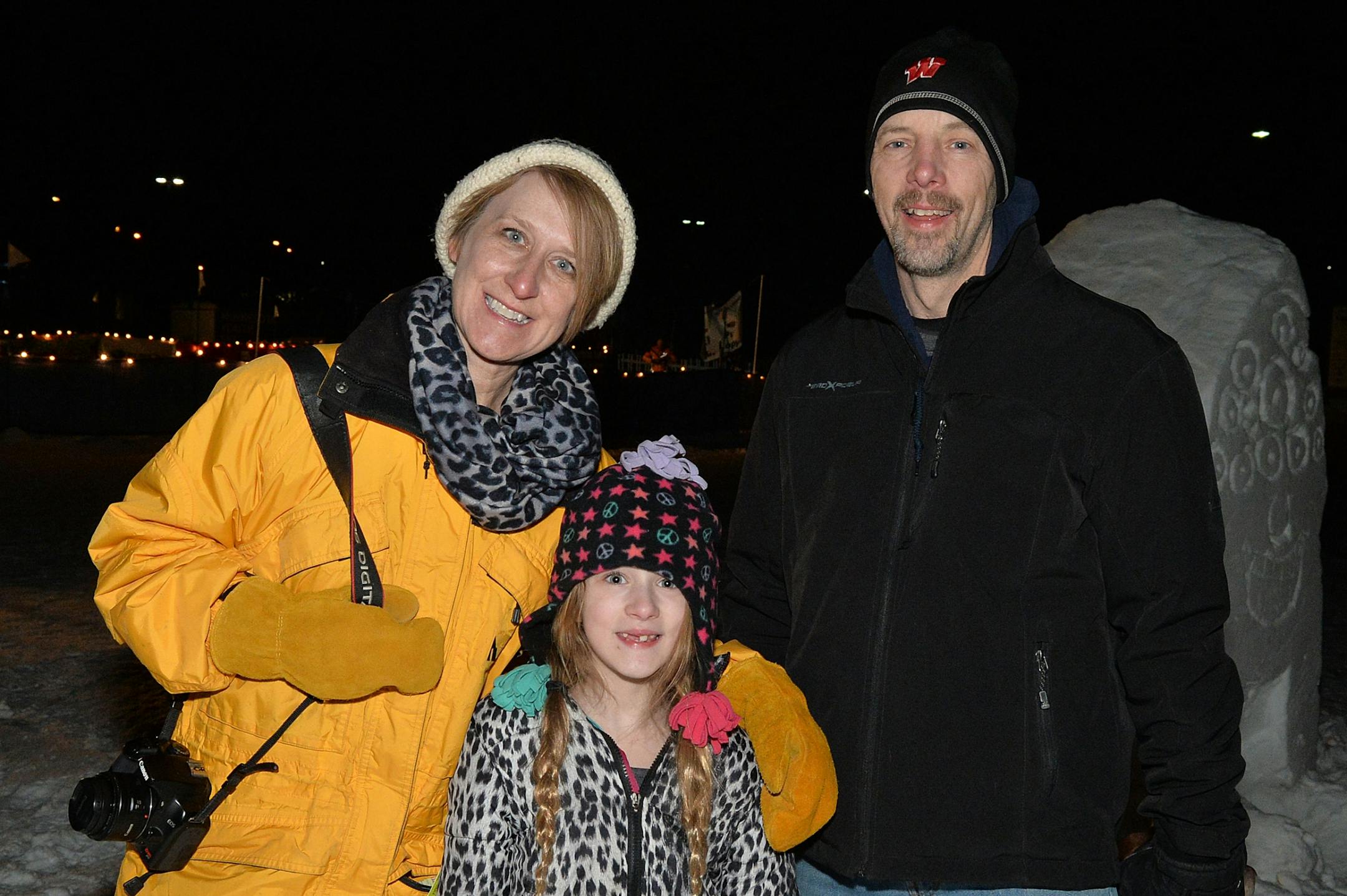Megan Binkowski (center) admires the snow sculptures with her parents Shawn (left) and Mike.