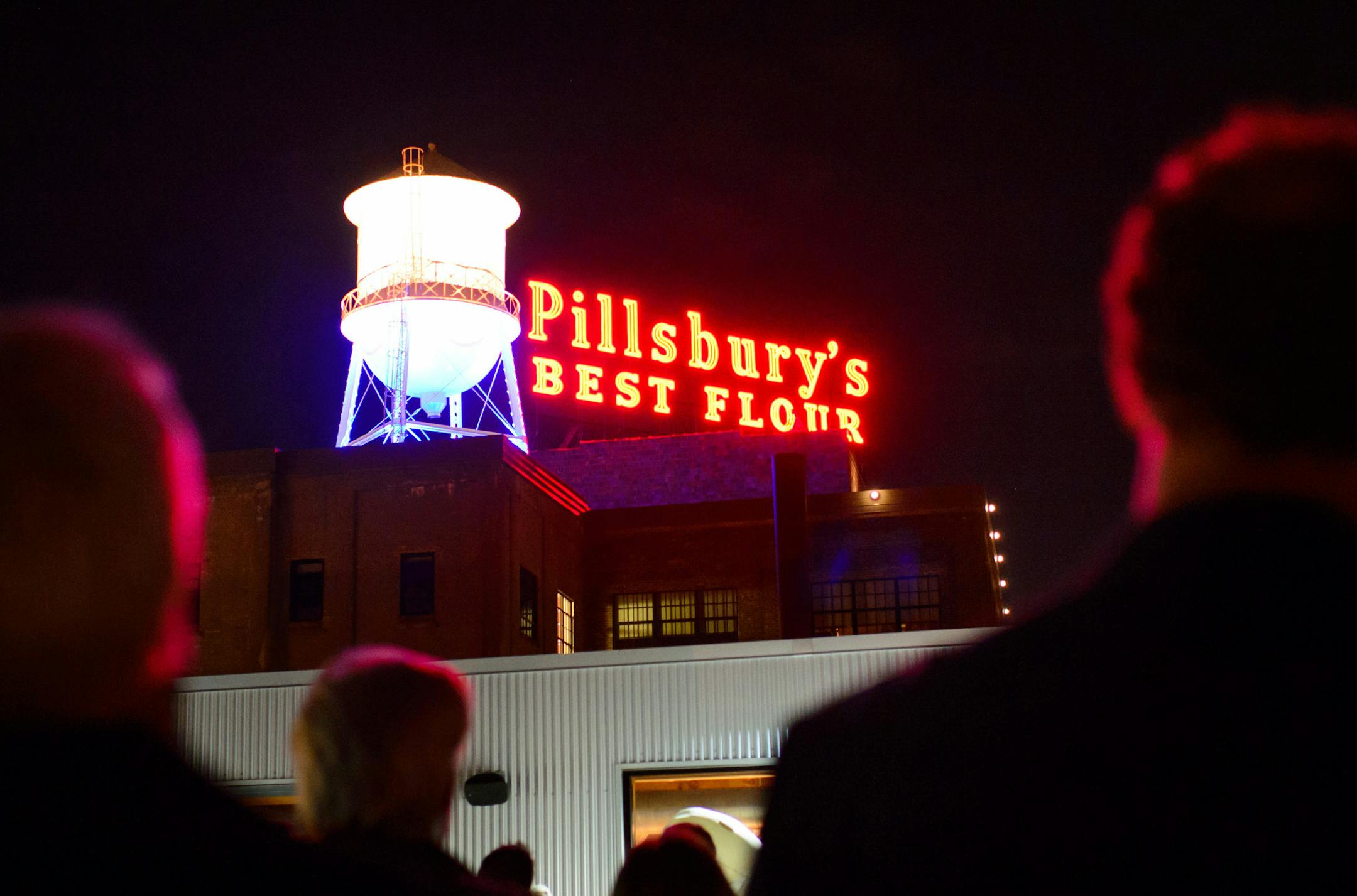 People cheered and applauded from the rooftop terrace of the A Mill Artist Lofts as the Pillsbury sign was relit Monday, Nov. 2, 2015, in Minneapolis. (Glen Stubbe/Star Tribune via AP)
