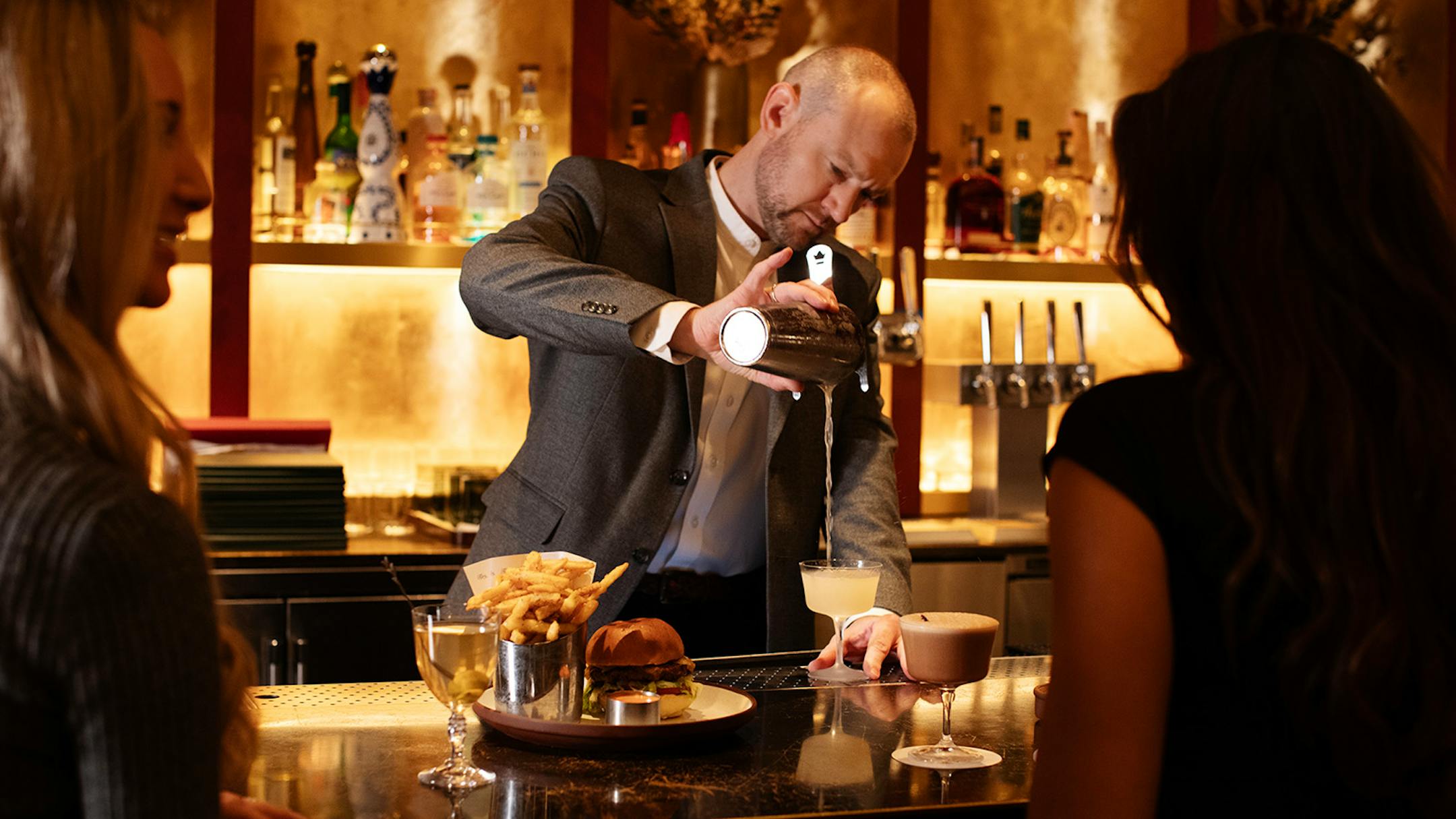 Pip Hanson behind the bar at Mara, pouring a cocktail