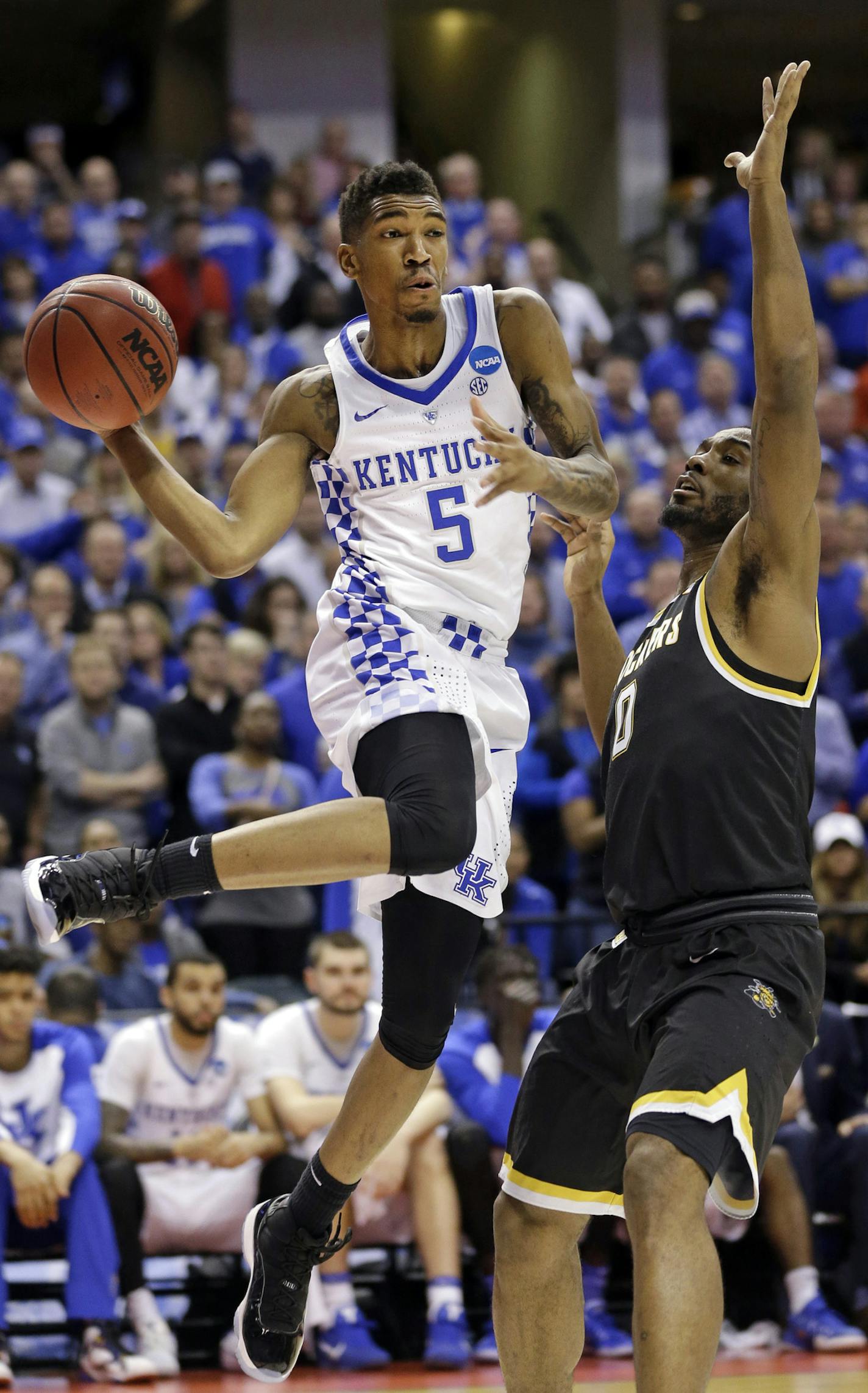 Kentucky guard Malik Monk (5) makes a pass around Wichita State forward Rashard Kelly (0) during the second half of a second-round game in the men&#xed;s NCAA college basketball tournament in Indianapolis, Sunday, March 19, 2017. Kentucky defeated Wichita State 65-62. (AP Photo/Michael Conroy) ORG XMIT: INMC136