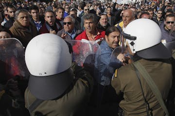 Anti-austerity protesters scuffle with riot police during a student parade in Athens, on Friday, Oct. 28, 2011. The student march, in commemoration of