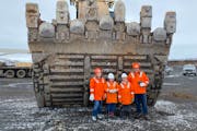 Aimee, Delphine, Julien and Nathan Munson stood in front of the bucket of an excavator at the Keetac mine on the Iron Range during a tour in April.