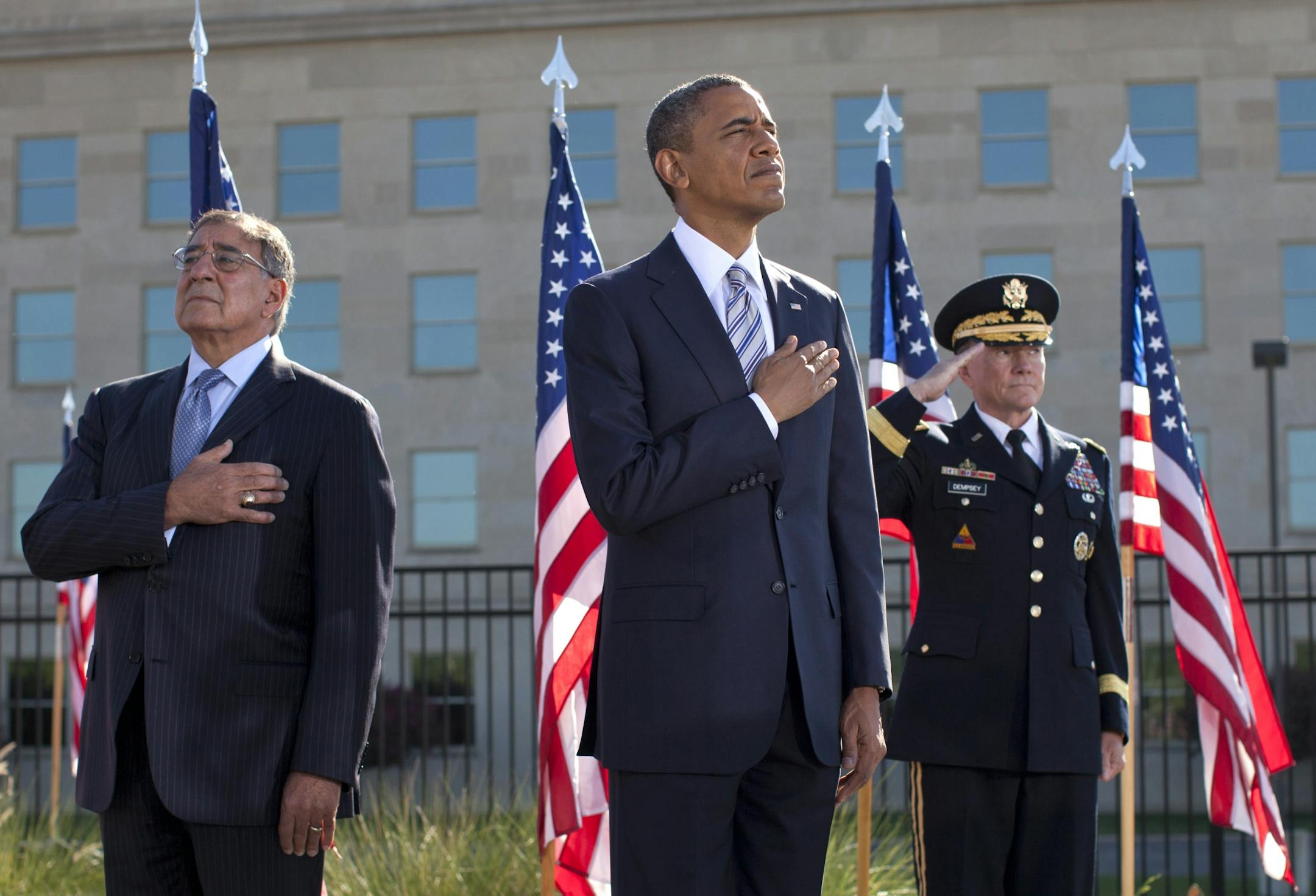 President Barack Obama, flanked by Defense Defense Leon Panetta, left, and Joint Chiefs Chairman Gen. Martin Dempsey, place their hands over their hearts at the Pentagon Memorial on Sept. 11, 2012.