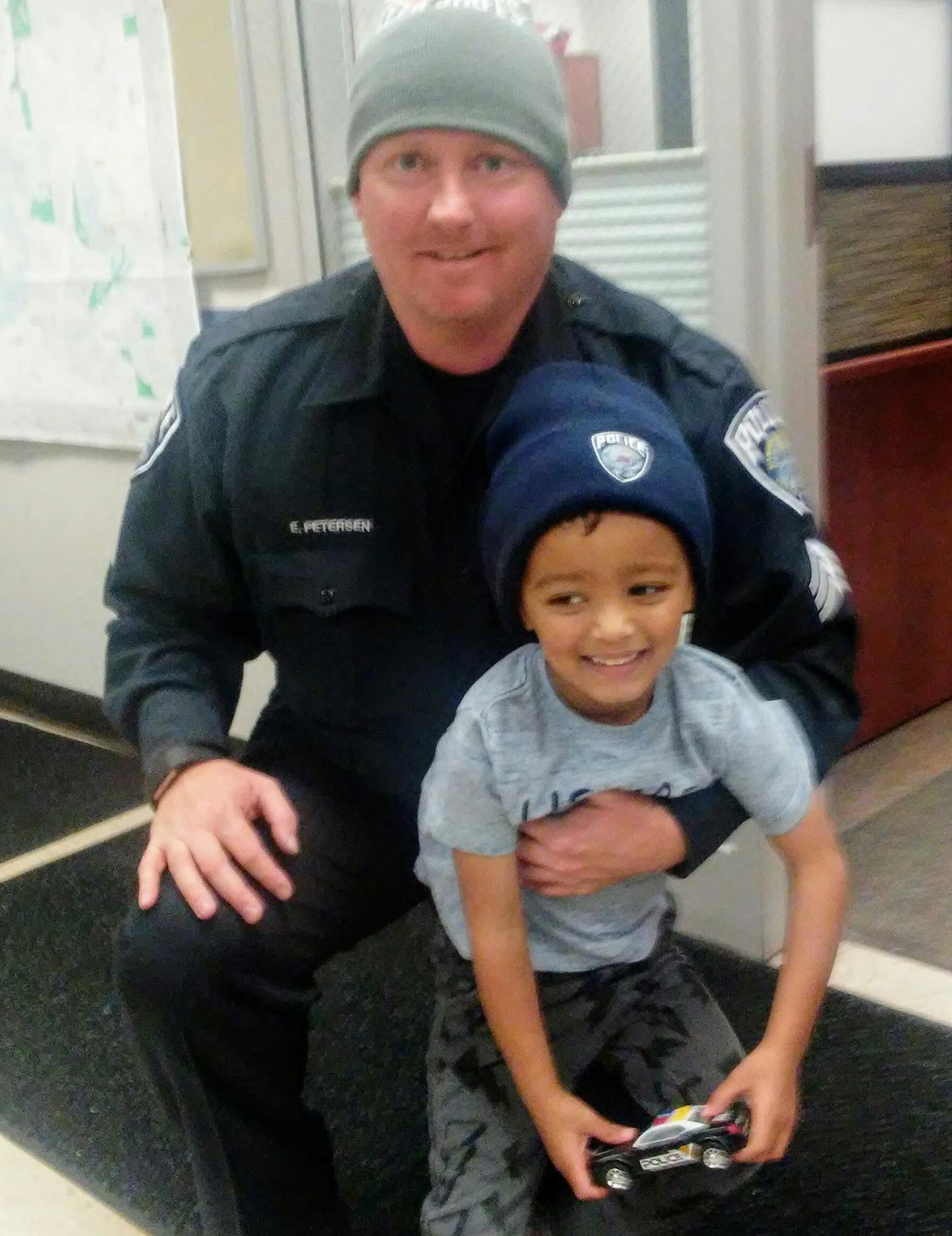 Mendota Heights police sgt. Eric Petersen stands with 4-year-old Gabriel Abdirahman after the department threw the boy a surprise birthday party.