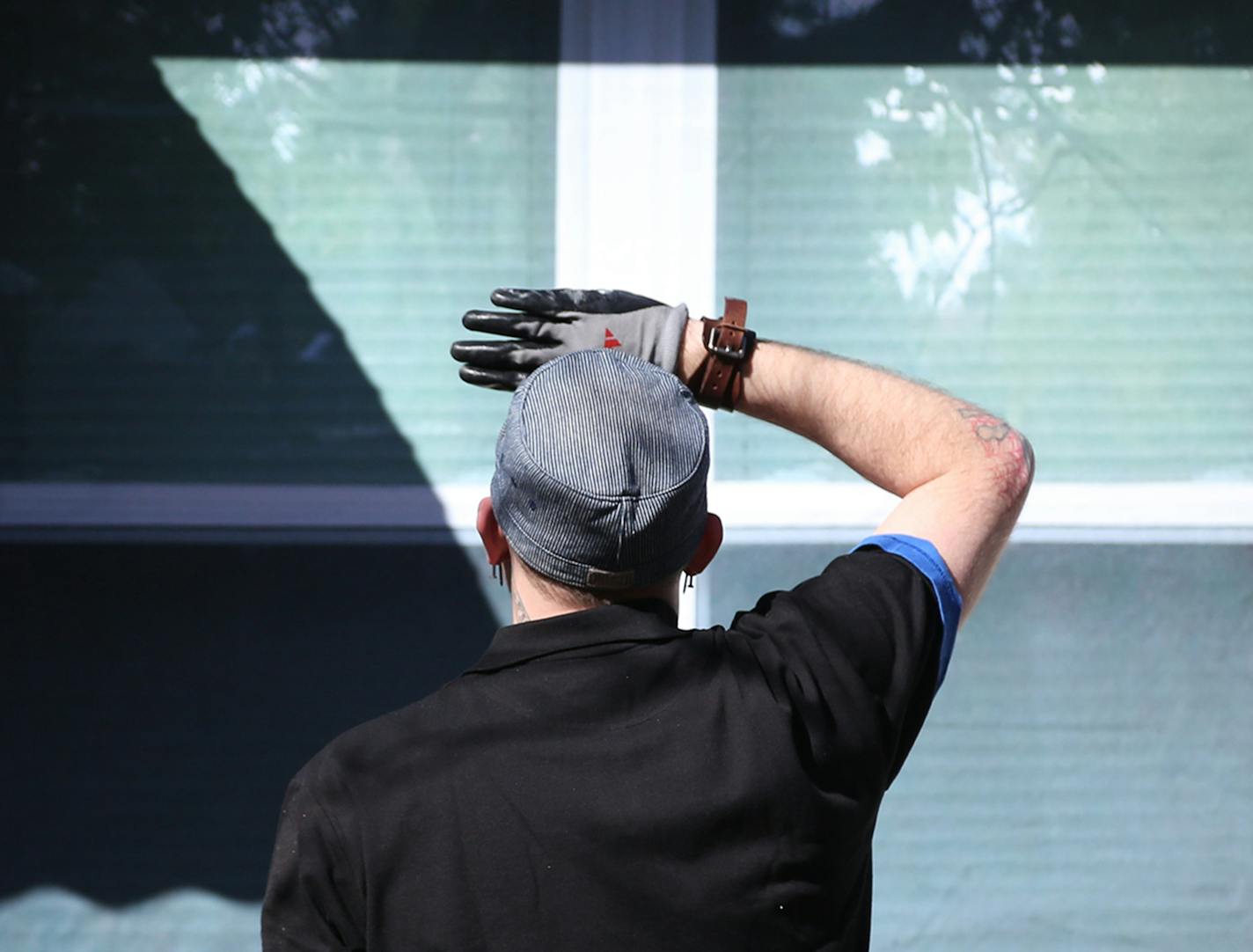 James Sorenson, senior property management Specialist for Hennepin County, looked for bubbles and straightness after he and Tim Korby, of Korby's Handyman Services, installed the vinyl coverings onto the boarded up windows on this home. ] (KYNDELL HARKNESS/STAR TRIBUNE) kyndell.harkness@startribune.com At a forfeited home in Minneapolis Min., Thursday, March 31, 2014. Hennepin county installed the vinyl covering for the boarded up windows and door it has purchased from Michigan-based Home Illusi