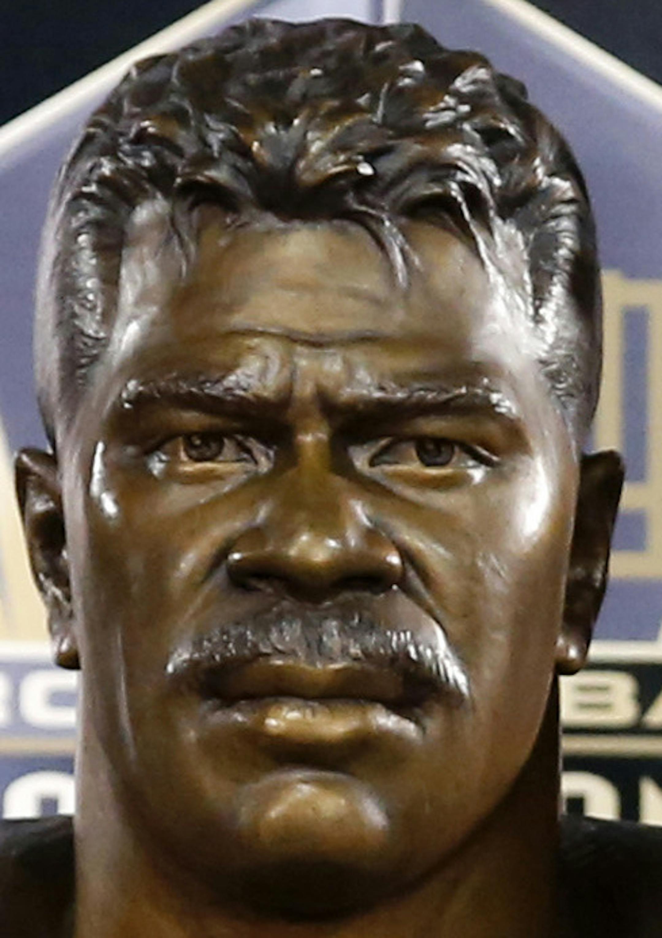 Sydney Seau, aughter of former NFL player Junior Seau, poses with a bust of her father during inductions at the Pro Football Hall of Fame Saturday, Aug. 8, 2015, in Canton, Ohio. (AP Photo/Gene J. Puskar)