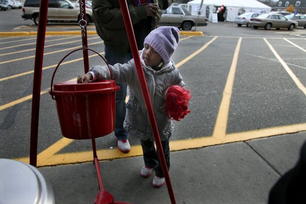 Three-year-old Lauren Walker joined her mother Latrice Jackson to a trip to the Salvation Army kettle to give before they shop at the St. Louis Park C