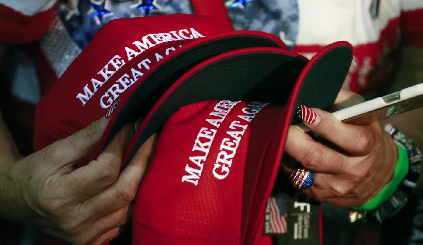 FILE - In this June 2, 2016, file photo, a woman holds hats to get them autographed by Republican presidential candidate Donald Trump during a rally in San Jose, Calif. Trump&#xed;s &#xec;Make America Great Again&#xee; hats proudly tout they are &#xec;Made in USA.&#xee; Not necessarily always the case, an Associated Press review found. (AP Photo/Jae C. Hong) ORG XMIT: WX204