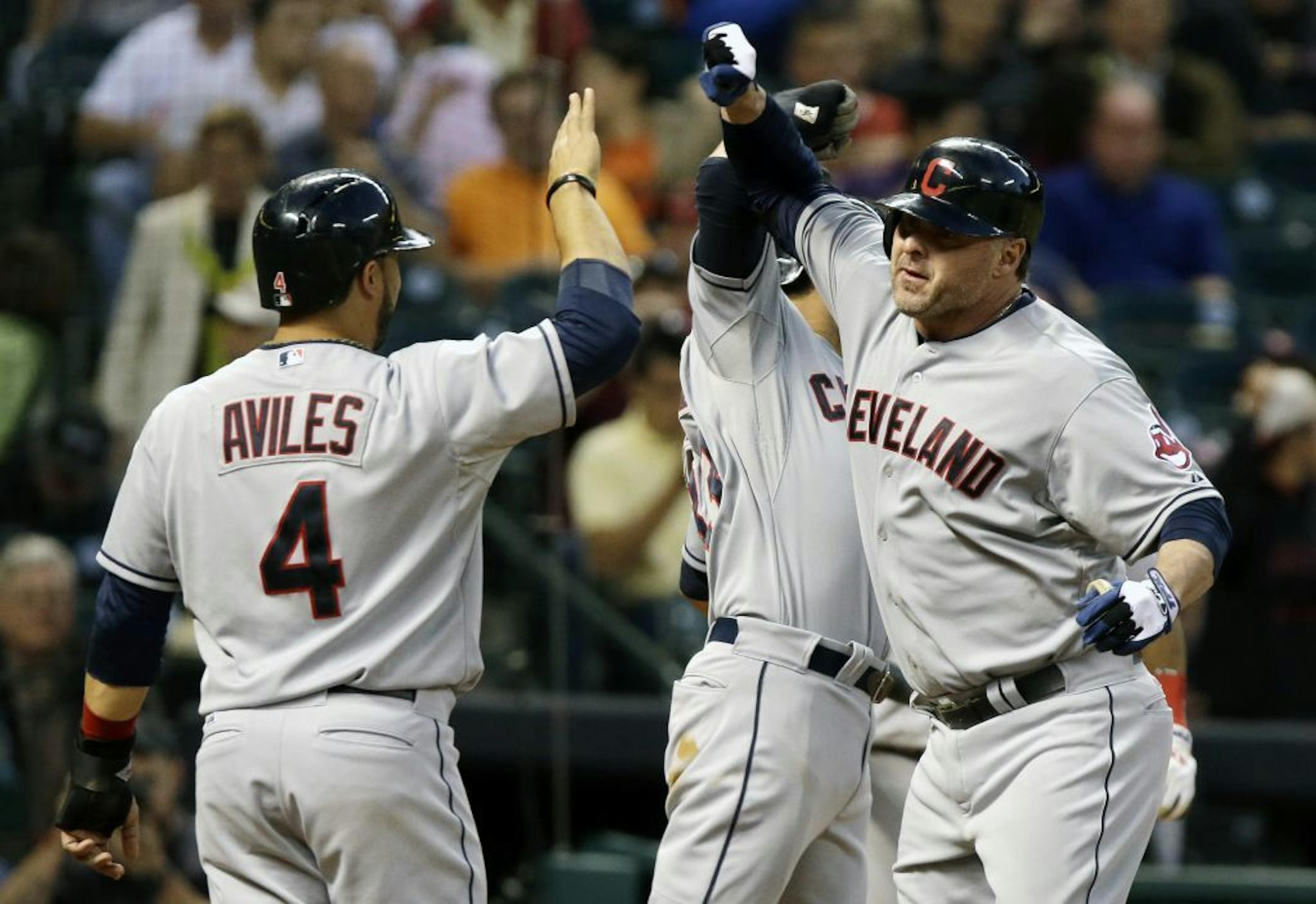 Cleveland Indians' Jason Giambi, right, celebrates his three-run home run against the Houston Astros with teammates Mike Aviles and Mike Aviles in the fourth inning of a baseball game on Saturday, April 20, 2013, in Houston.